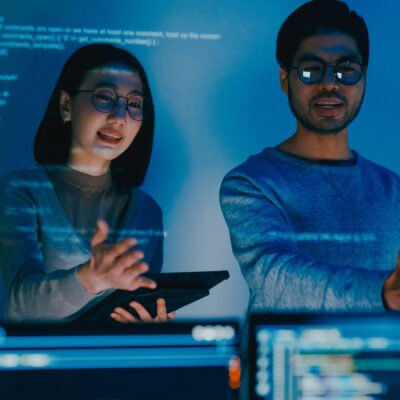 Group adult Asia male female software developers mentor leader manager talk strategy plan to executive write prompt AI bot IT app program nomad, video game, data center. Projecting slideshow code.